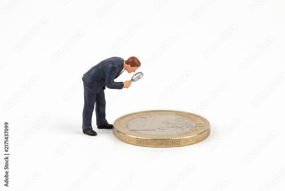 Obraz premium ユーロ硬貨を観察するビジネスマン