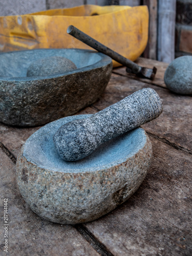 Canvastavla Traditional stone mortar and pestle displayed on a rustic wooden workbench, surrounded by natural stones, hand tools, and workshop materials