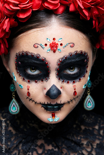 Halloween beauty close-up portrait of woman. Beautiful female face adorned with Santa Muerte makeup.