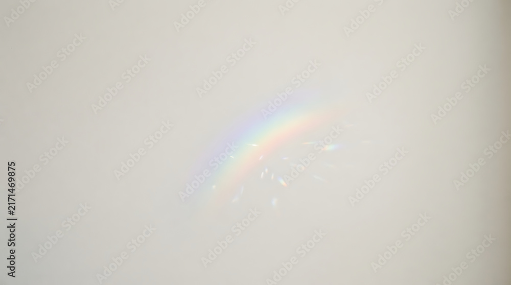 Naklejka premium Soft rainbow reflection on a light neutral wall casting gentle prismatic colors and ambient light
