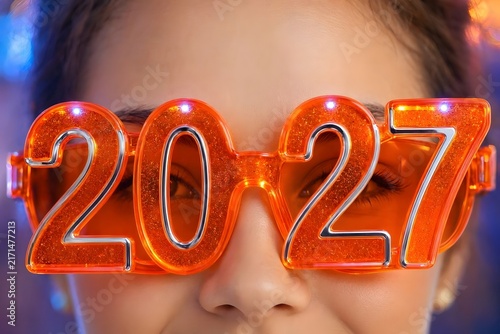 Woman wearing funny orange 2027 glasses celebrating party in bokeh light style