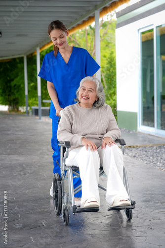 Bild auf Leinwand Caregiver nurse senior woman wheelchair healthcare patient assistance facility n