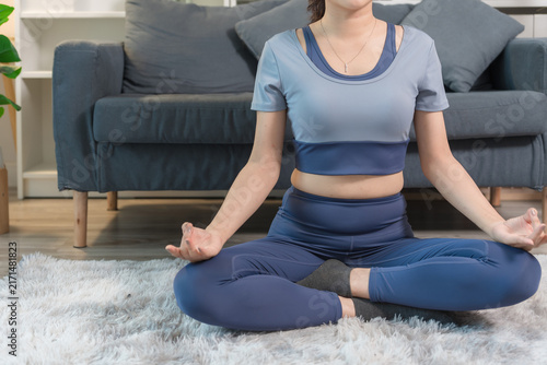 A sporty woman in sportswear exercises at home	