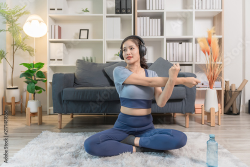 A sporty woman in sportswear exercises at home	
