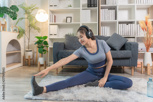 A sporty woman in sportswear exercises at home	