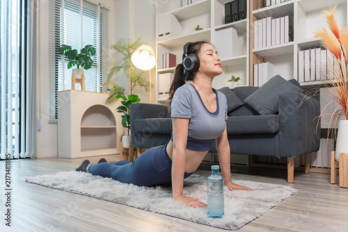 A sporty woman in sportswear exercises at home	