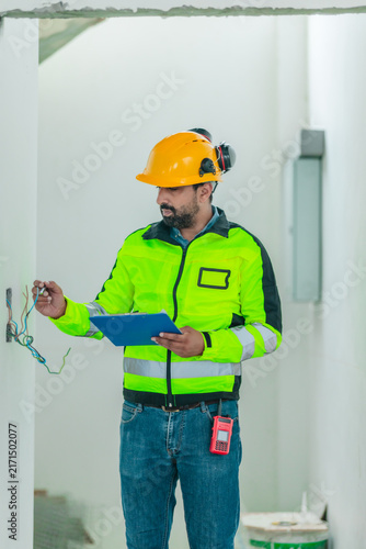 Engineer inspector with clipboard checking and inspecting house construction site interior