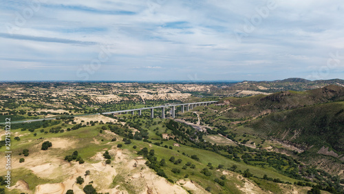Aerial shot of Saling River Grand Bridge spanning across the river. Grand bridge construction integrated with natural landscape, transportation infrastructure in Inner Mongolia grassland area.