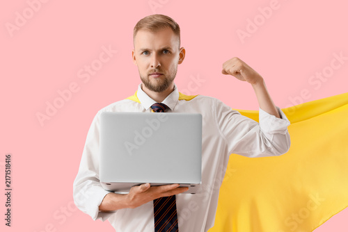 Bild auf Leinwand Business superhero concept, confident man in cape holding laptop and flexing arm
