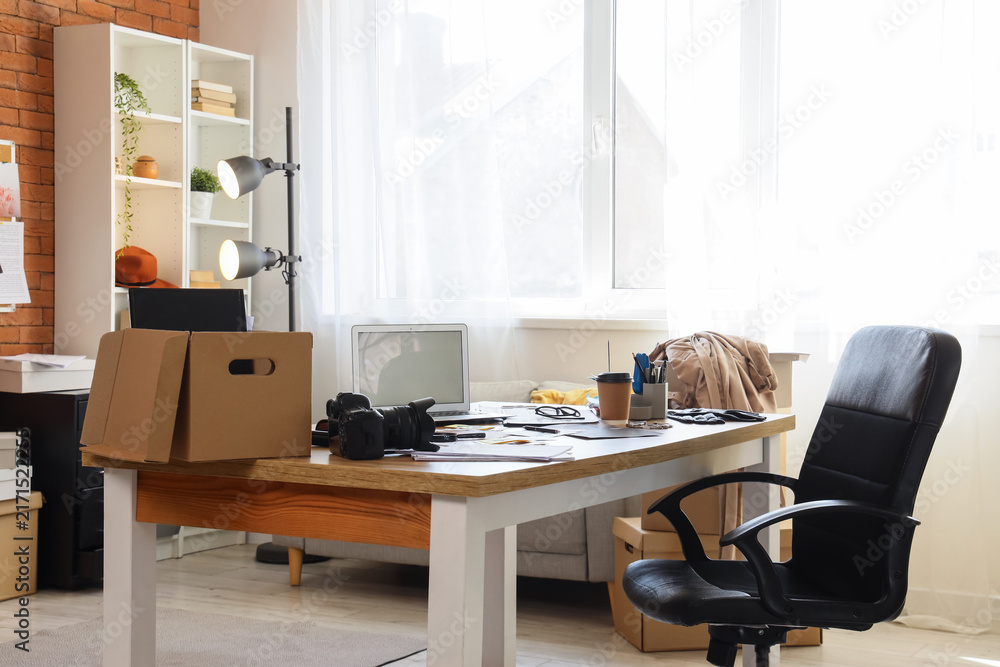 Fototapeta premium Remote work and home office setup empty desk with laptop camera and moving boxes freelance creative workspace