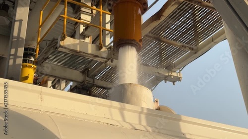 An industrial tanker fills from a high‑pressure overhead pipe at a refilling bay near EGA in Dubai’s logistics zone.