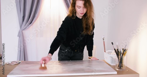 Creative hobby. Art paint. Female professional master enjoying handmade color drawing using canvas paintbrush at workspace.