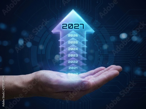 Conceptual image of a hand holding a glowing holographic arrow pointing upwards with years from 2020 to 2027, representing business growth and future planning