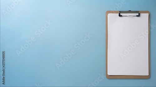 Brown clipboard with blank white paper on a sky-blue background with copy space. Clean modern office and education concept