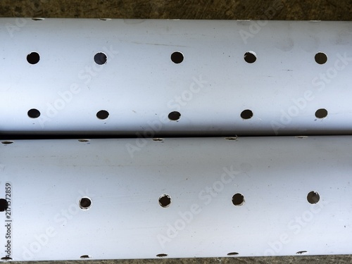 Parallel perforated plastic PVC tubes prepared for hydroponic farming, agriculture, or drainage system.