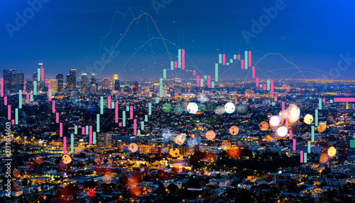 Fotografie Double exposure of a sprawling city skyline at night and a glowing financial stock market chart, representing urban economic growth, global investment, and modern business technology development