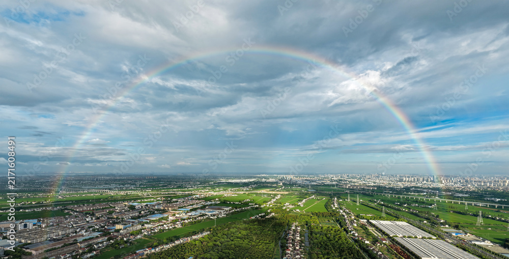 Naklejka premium Full Rainbow Over Urban and Rural Landscape