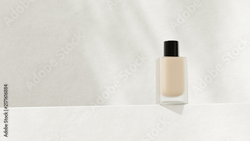 Konstfotografi One glass foundation bottle with a black cap on a white stone ledge in front of a textured ivory plaster wall in soft natural light