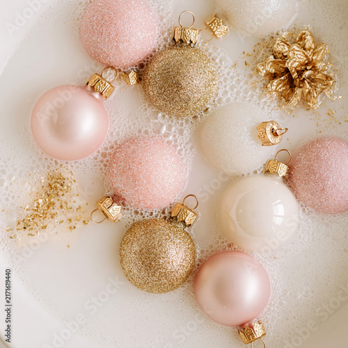 Baubles floating in milk bath with bubbles and decorations