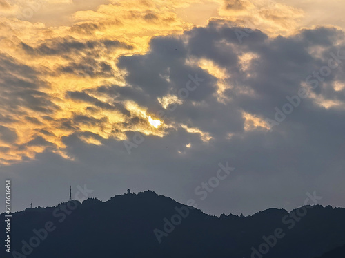 Dramatic sunset clouds over dark mountain ridge