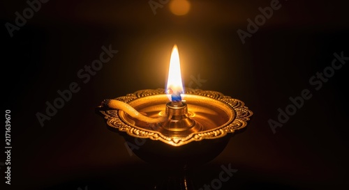 A glowing traditional oil lamp flickers against a dark background, creating a warm atmosphere for the magical spiritual festival of lights, clay, bokeh, peace