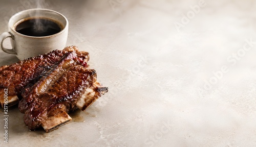 Grilled beef ribs with hot coffee and copy space for restaurant menu advertising.