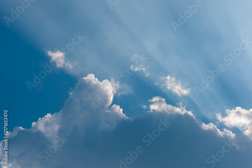 Foto Sunbeams breaking through clouds in blue sky, crepuscular rays god rays backgrou
