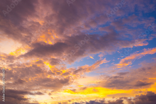 Stunning vibrant sunset sky with colorful clouds and twilight glow,A breathtaking view of a vibrant sunset sky filled with dramatic colorful clouds, glowing golden light, and soft purple twilight hues