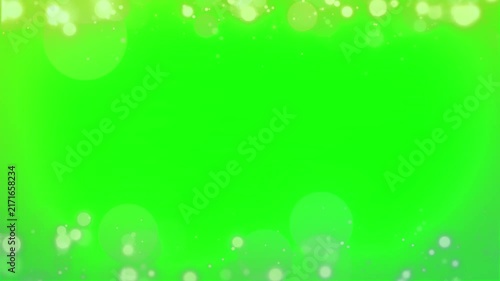 Bokeh light circles create a glowing border along the top and bottom of a bright green chroma key background screen.