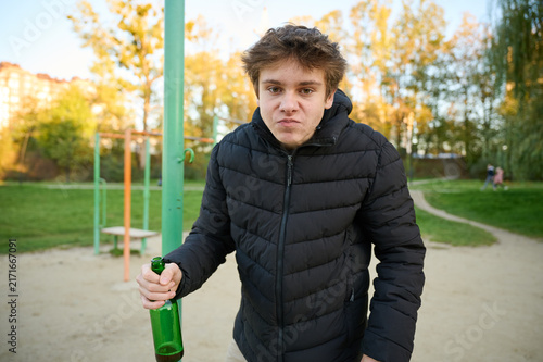 Quadro su tela Teen boy with bottle poses in public recreation space
