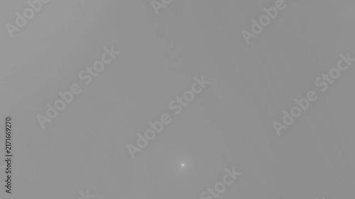 Lens flare light shines subtly at the bottom center of a smooth grey neutral backdrop with clear copy space.