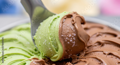 Ice cream scoop lifts a blend of matcha green tea and chocolate flavors for a sweet dessert.
