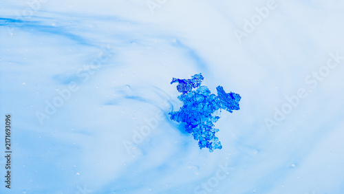 Photography Blue crystal dissolving in abstract liquid creating fluid shapes