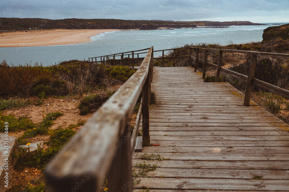 Obraz premium Wooden walkway leading down to a coastal beach