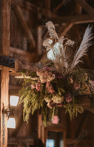Картината върху платно Rustic floral arrangement hanging on a wooden beam