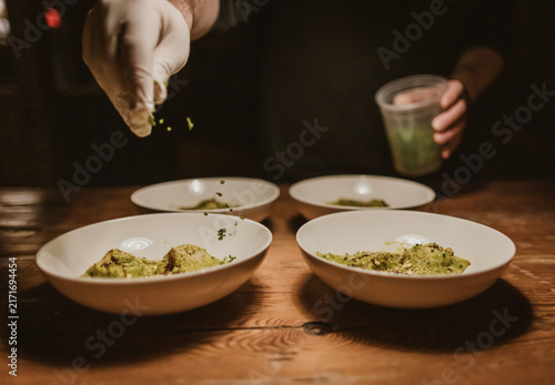 Fotografie Chef puts finishing touches on four pasta bowls
