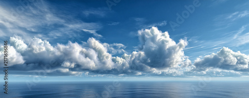Horizon of Hope A panoramic view of a vast blue sky filled with dramatic cumulus clouds stretching across the horizon above a calm, reflective ocean.