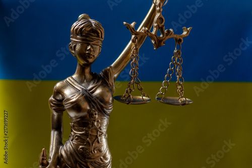 Ukrainian flag with Lady Justice statue and scales
