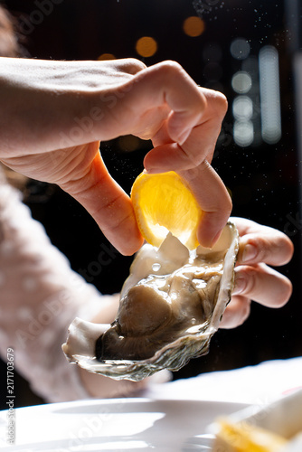 Foto Squeezing Lemon Juice on Fresh Oyster