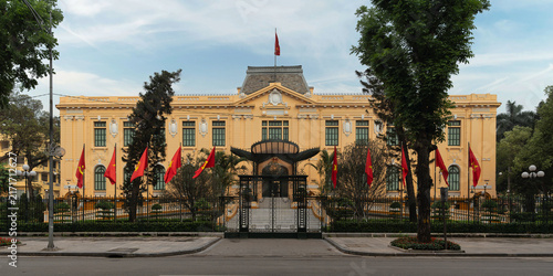 Historic French colonial Government Guest House in Hanoi, Vietnam, situated beside Vuon hoa Dien Hong or Frog Garden. Exterior view featuring yellow walls and national flags