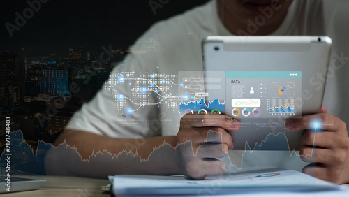 Business technology concept featuring a professional using a tablet with digital dashboard, data analytics, charts and global network interface,representing digital transformation and modern business.
