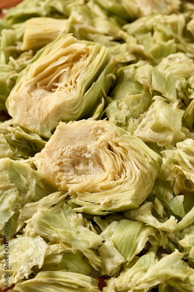 Obraz premium Organic Artichoke Hearts And Sliced Petal Pieces Freshly Harvested Vegetable Texture Background.