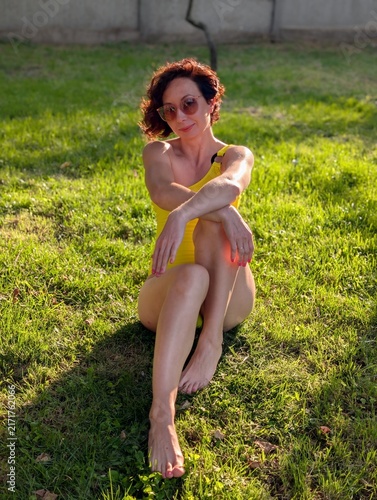 Woman Relaxing on Grass in Yellow Swimsuit