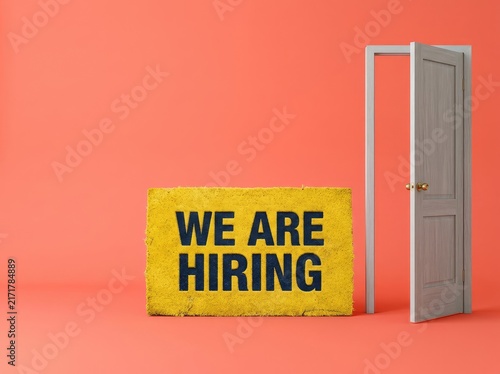 Yellow doormat reading WE ARE HIRING next to an open door suitable for recruitment content symbolizing career opportunities and growth