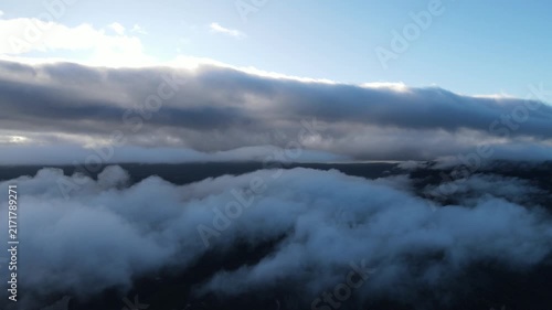 Aerial Drone Flight Above a Low Layer of Clouds, with the Sun Peeking Through Higher Clouds Above, Creating a Peaceful Atmospheric Sky Scene with Soft Natural Light
