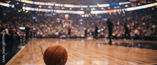 A cinematic basketball game night rendered fully blurred, with glowing arena lights, soft player silhouettes, court reflections, and atmospheric bokeh creating energetic sports wallpaper