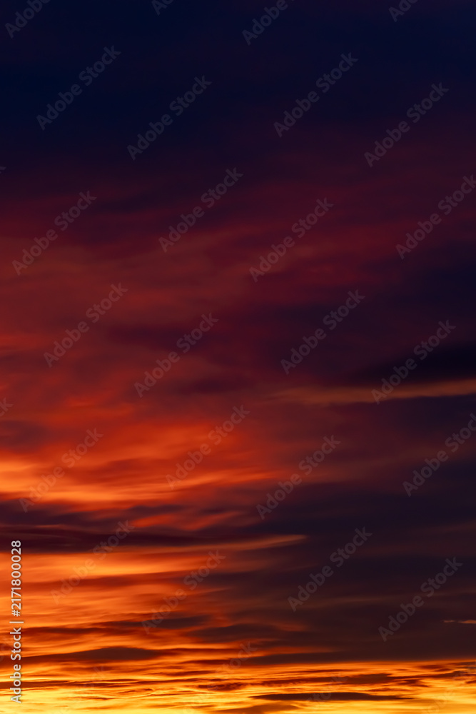 Fototapeta premium Dramatic sunset sky with colorful glowing clouds and deep purple hues for atmospheric background