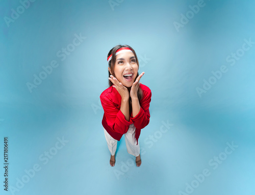 Happy young Indonesian woman is standing and posing smiling to the camera.