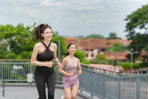 Canvas Print Asian women running outdoors on city bridge for morning jog and healthy fitness