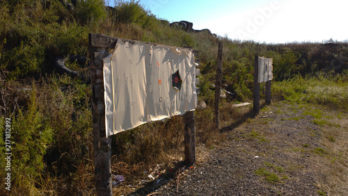 Fotografie Paper Target Board with Bullet Holes at Outdoor Shooting Range
